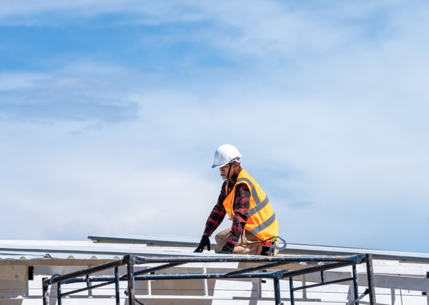 Worker performing commercial roof inspection