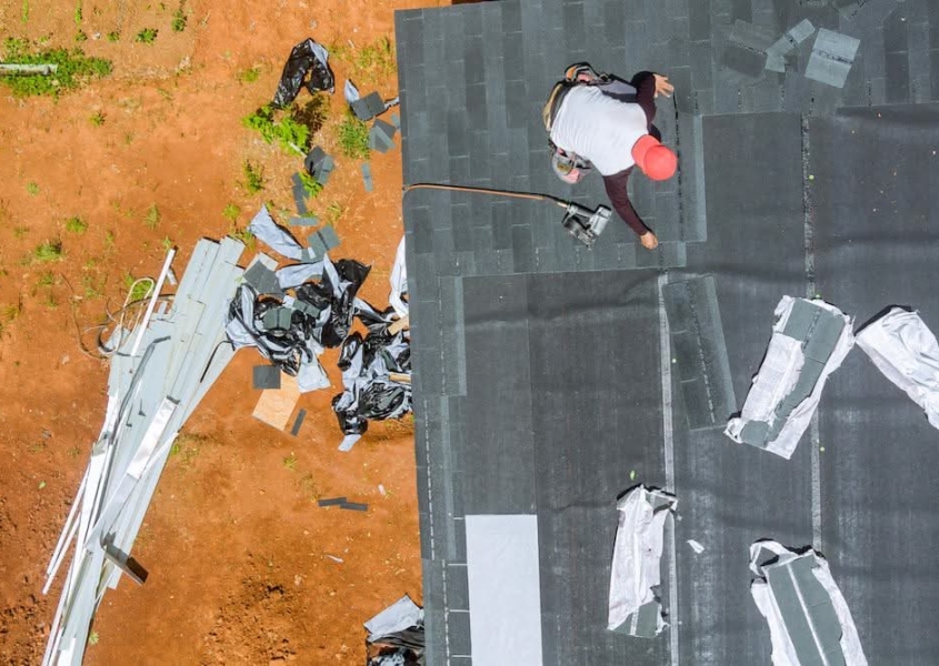Worker replacing a leaky roof
