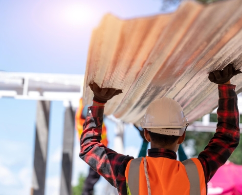 Commercial roofing contractor carrying metal roofing