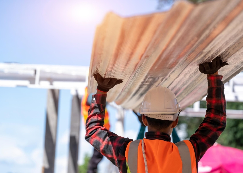 Commercial roofing contractor carrying metal roofing