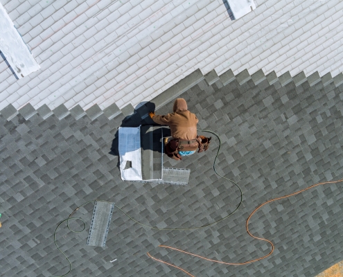 A skilled worker replaces shingles on a roof