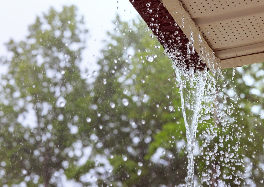 Rain water pouring off a roof during a storm