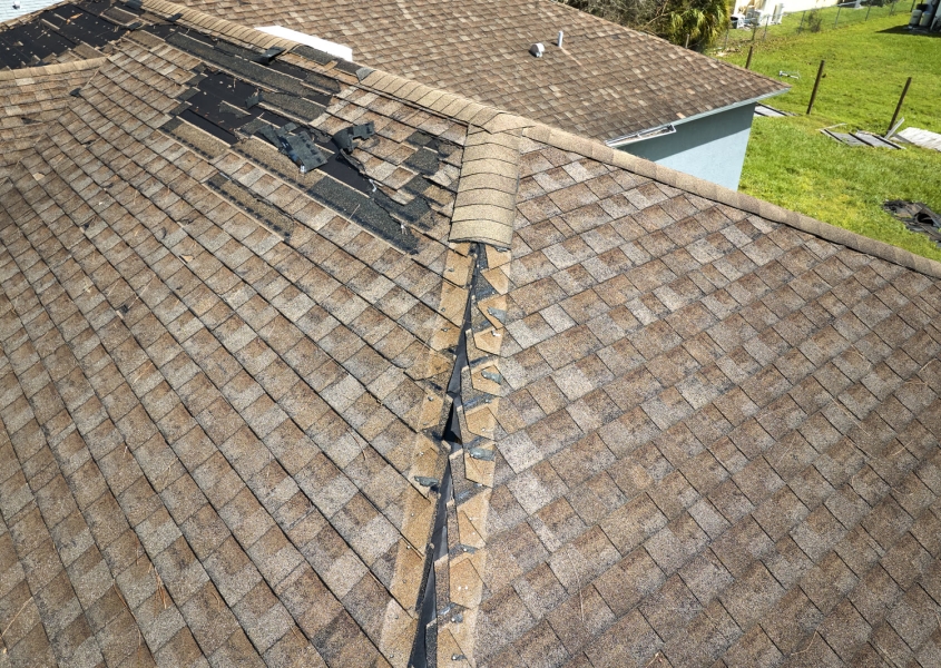 Damaged roof with missing shingles that needs replacing