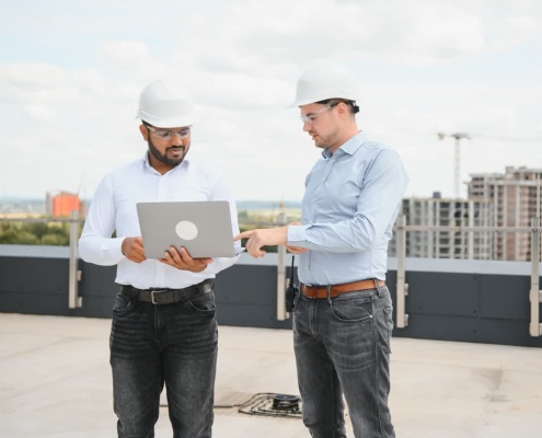 A business owner reviewing a document explaining commercial roof warranties with a professional roofer.
