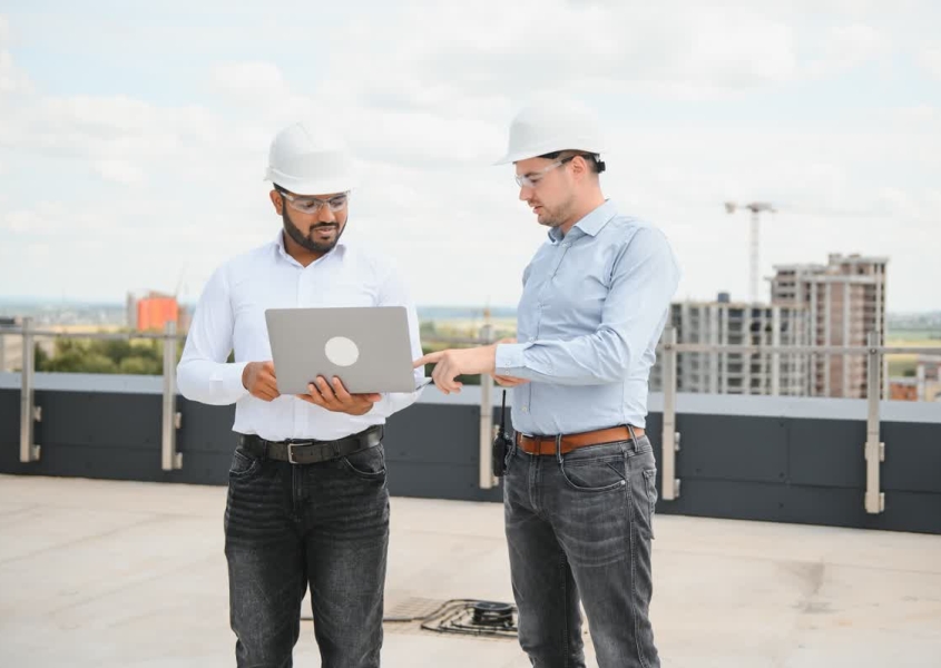 A business owner reviewing a document explaining commercial roof warranties with a professional roofer.