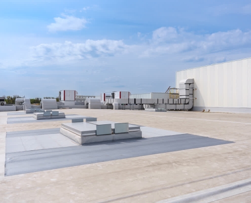 Modern commercial building showcasing 2025 commercial roofing trends with smart sensors and reflective cool roof technology