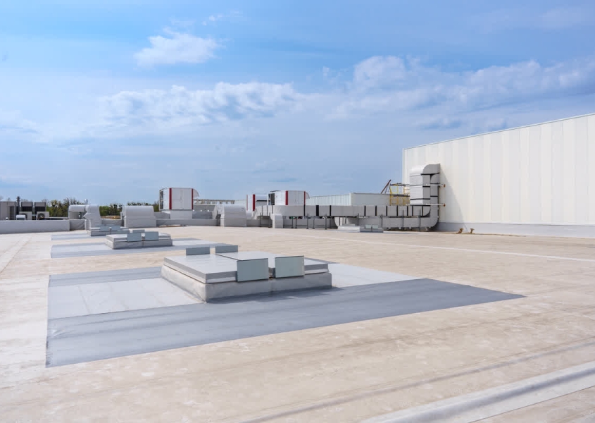 Modern commercial building showcasing 2025 commercial roofing trends with smart sensors and reflective cool roof technology