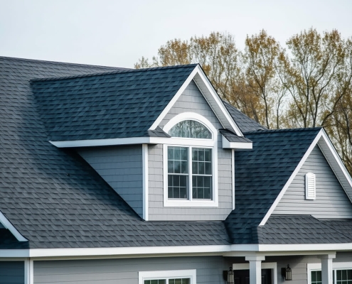 Homeowner inspecting aging roof shingles for replacement