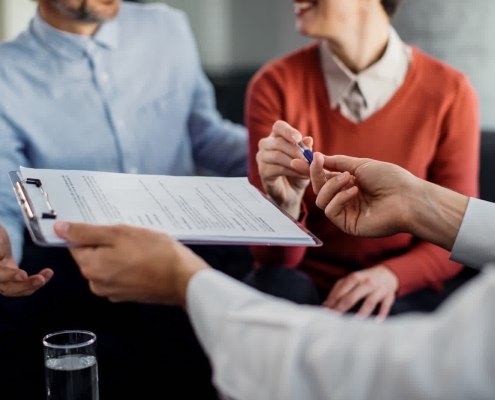 Roofing professional helping homeowner with roof insurance claim paperwork