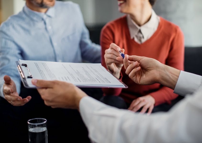 Roofing professional helping homeowner with roof insurance claim paperwork