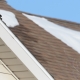 Roofer removing snow from residential roof in Wisconsin winter
