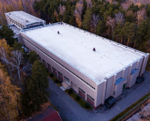 Aging flat commercial roof showing commercial roof deferred maintenance risks