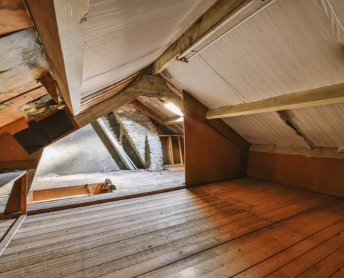 Attic inspection revealing hidden roof damage in insulation and framing