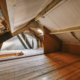 Attic inspection revealing hidden roof damage in insulation and framing
