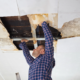 Roofer performing commercial roof leak diagnosis with moisture mapping and infrared detection tools