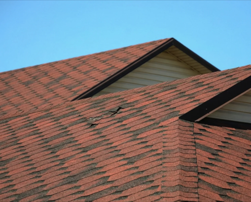 Residential roof showing common home inspection roof issues like missing shingles and damaged flashing