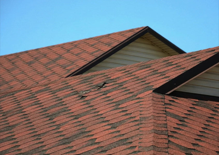 Residential roof showing common home inspection roof issues like missing shingles and damaged flashing