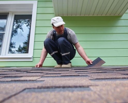 Homeowner attempting a DIY repair, illustrating common roofing mistakes homeowners make
