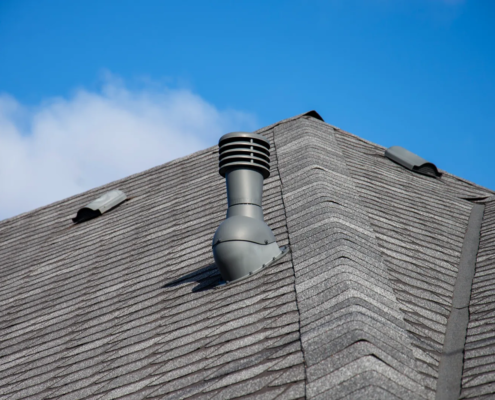 Roofer inspecting attic intake vents to identify roof ventilation problems