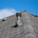 Roofer inspecting attic intake vents to identify roof ventilation problems