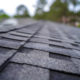 Roofer installing asphalt shingles on a residential home for a new roof project