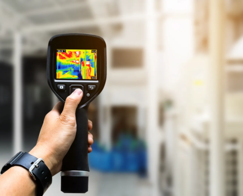 Technician about to perform an infrared roof scan on a large commercial flat roof.